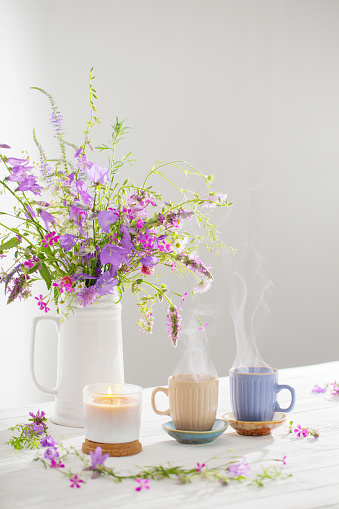 herbal tea with summer wild flowers on white wooden table