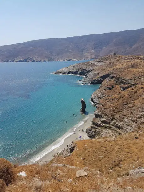 Photo of greece andros island beach called tis grias to pidima, rock high in the sea