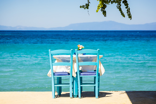 Two chairs with table on the terrace with sea view in Santorini Island, Greece.