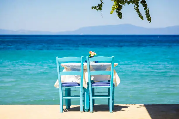 Table and chairs in Kokkari village, Samos island, Dodecanese, Greece in afternoon.
