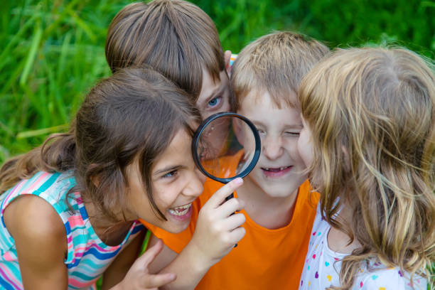 istock Cute Girl Looking Through Magnifying Glass 1412913172