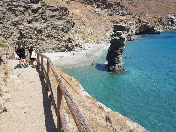 Photo of greece andros island beach called tis grias to pidima, rock high in the sea