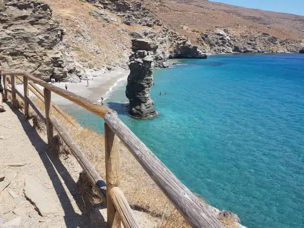 Photo of greece andros island beach called tis grias to pidima, rock high in the sea
