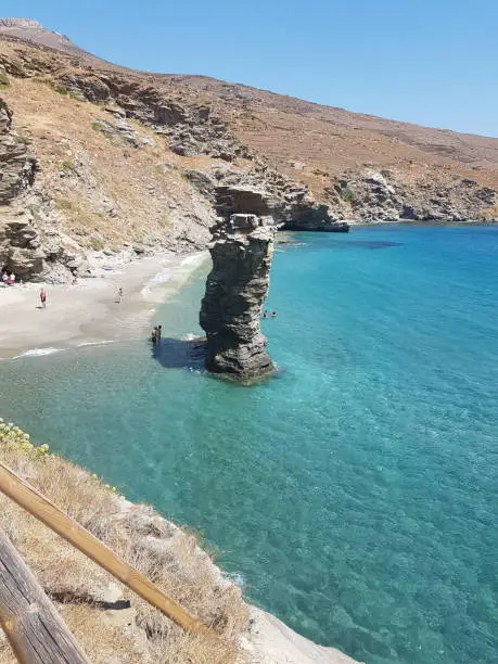 Photo of greece andros island beach called tis grias to pidima, rock high in the sea