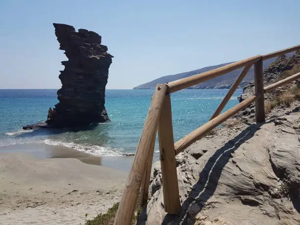 Photo of greece andros island beach called tis grias to pidima, rock high in the sea