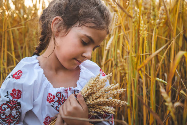 istock Cute Girl Holding Wheat Crops Standing On Field 1412916270