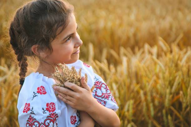 istock Cute Girl Holding Wheat Crops Standing On Field 1412916281