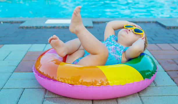 istock Cute Baby Lying On Inflatable Ring By Swimming Pool 1412916290