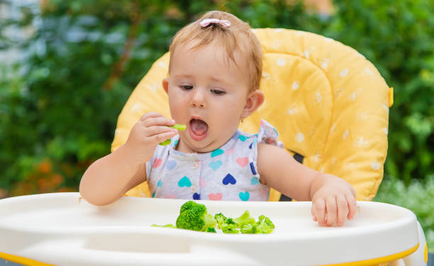 istock Cute Baby Eating Broccoli 1412917412