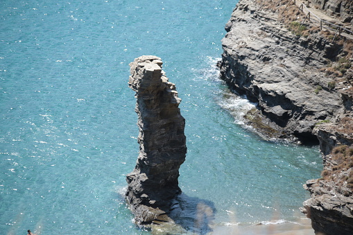 greece andros island beach called tis grias to pidima, rock high in the sea in summer season