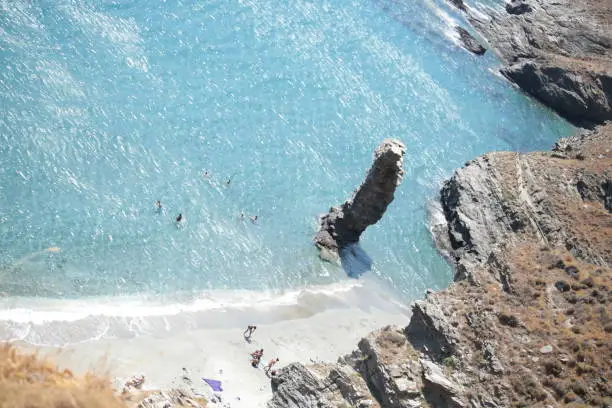 Photo of greece andros island beach called tis grias to pidima, rock high in the sea