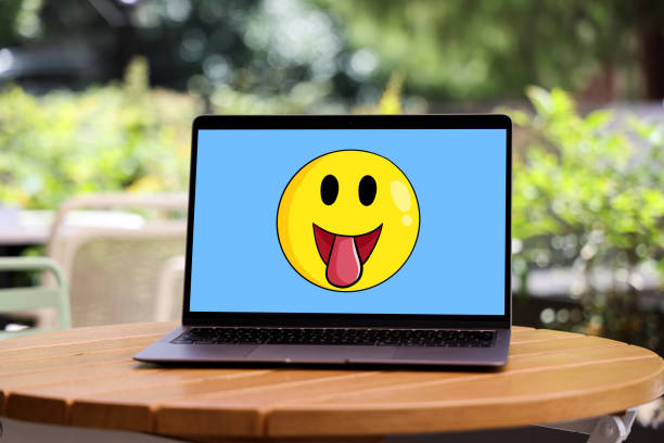 Yellow emoticon smiley face icon on laptop screen