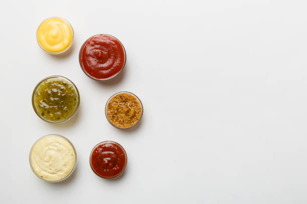 istock Different types of sauces in bowls on a colored Board . Top view. various sauces copy space 1412926101