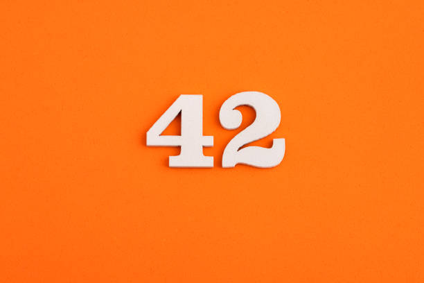 Number 42 - On orange foam rubber background White wooden number 42 on eva rubber orange background number 42 stock pictures, royalty-free photos & images