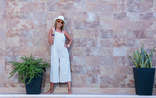 woman over 50 posing on wall with pool