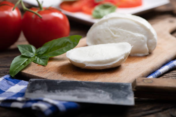 Fresh mozarella cheese on cutting board stock photo