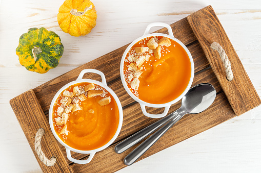Pumpkin soup with croutons on wooden tray. Top view. High quality photo