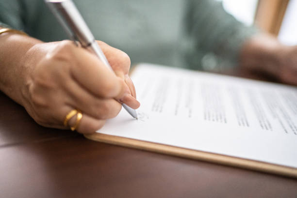Close-up of document being signed by woman stock photo