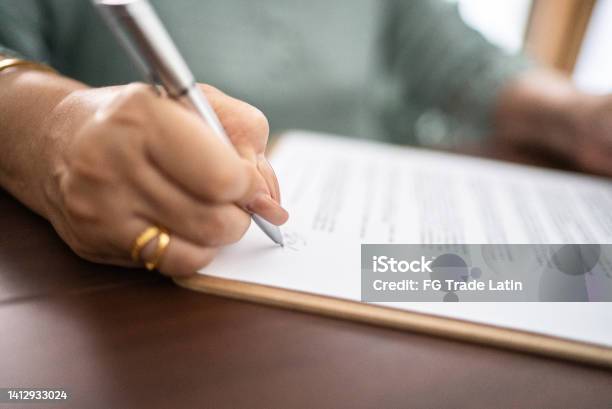 Closeup Of Document Being Signed By Woman Stock Photo - Download Image Now - Change, Lease Agreement, Certificate