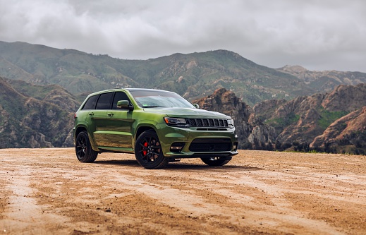 LA, CA, USA
6/22/2022
Jeep Grand Cherokee SRT parked with mountains with some green plants in the background