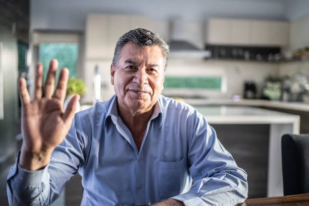 Senior man doing a video call at home - camera point of view