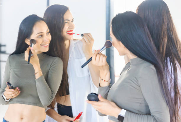 istock Women applying makeup together 1412934694