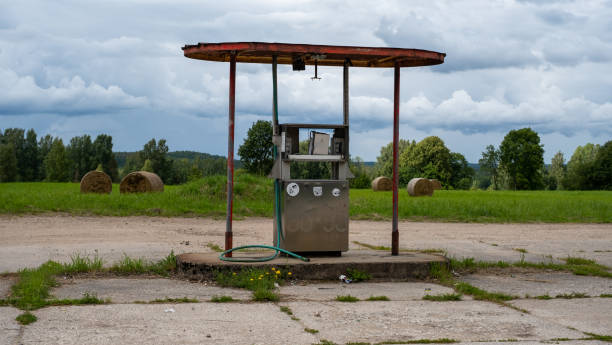 eine sehr alte zapfsäule in einer verlassenen station. die alte durchflussmessung, die an der pumpe an der tankstelle verwendet wurde. auf dem hintergrund einer schönen gemähten wiese. - conquered stock-fotos und bilder