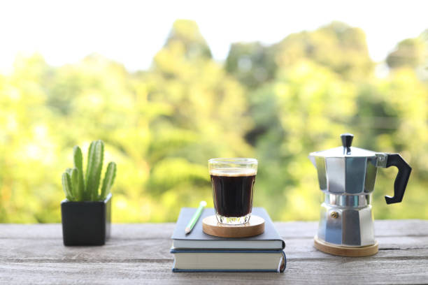 istock Brown coffee cup and cactus in black pot on wooden table 1412935862