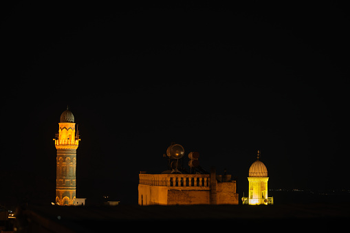 Night at Mardin City, Top view of ancient mosque minarets, illuminated building in ancient Mardin.