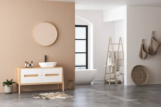 istock Modern bathroom interior with beige walls, white sink with oval mirror, bathtub 1412938389