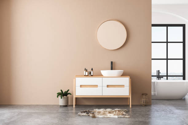 istock Modern bathroom interior with beige walls, white sink with oval mirror, bathtub 1412938539