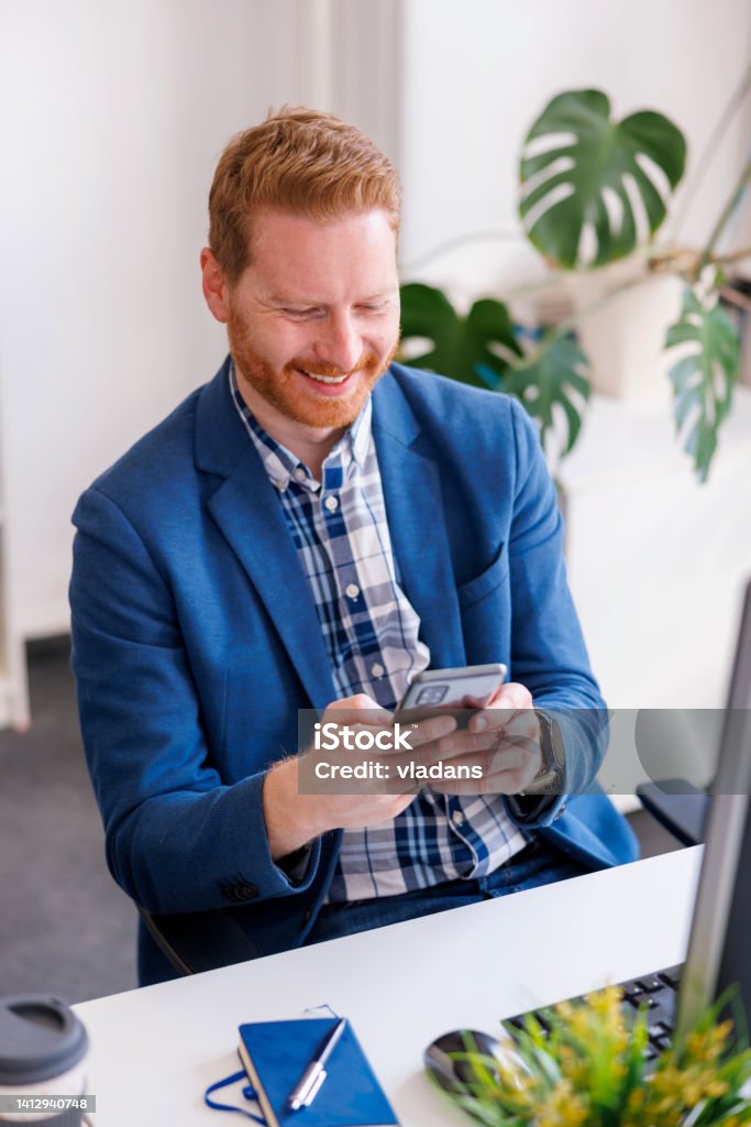 Businessman Typing Text Message Using Smart Phone While Working In An ...