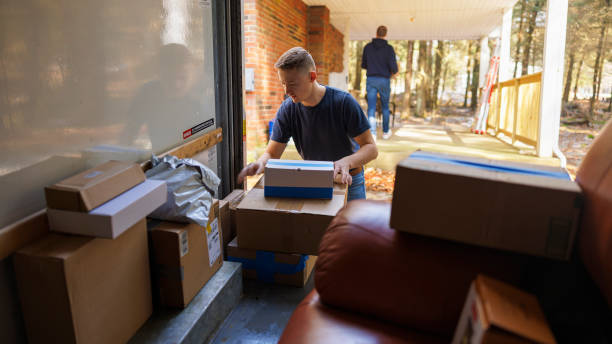 Moving into new house. Two men unloading boxes from truck. stock photo