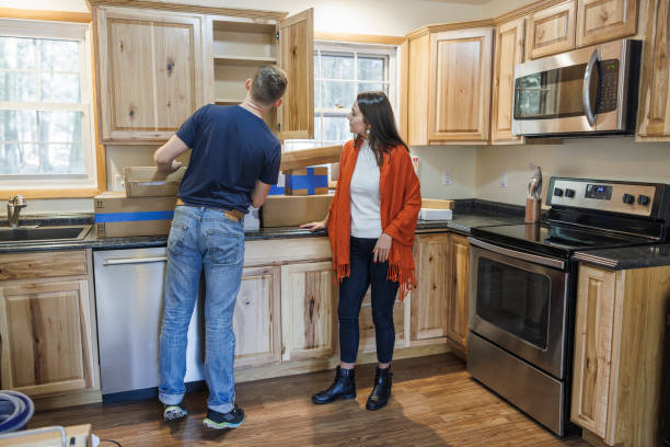 istock Settling down in new house. Married couple unpacking boxes in their kitchen. 1412942031