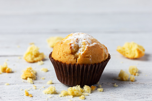 Freshly baked muffin on wooden white background with copy space.