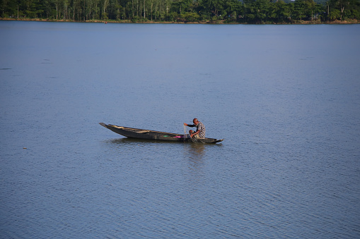 A fisherman is fishing in a small boat in the water of the lake at Sylhet in Bangladesh on 4 August, 2022.