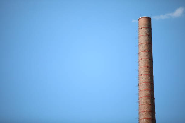 Old pipe made of bricks with the clouds imitating smoke coming out from the chimney, shut down plant save from global warming