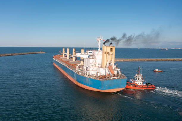 istock Tugboat towing a large cargo ship on sea. 1412948060