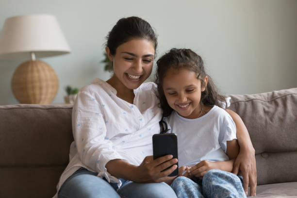 istock Happy Indian mum hugging kid, sitting on couch at home 1412950813