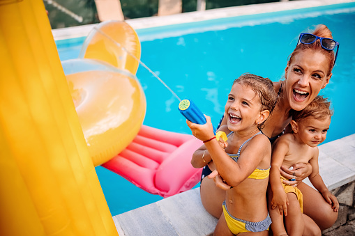 Mother is having fun at the pool with her children