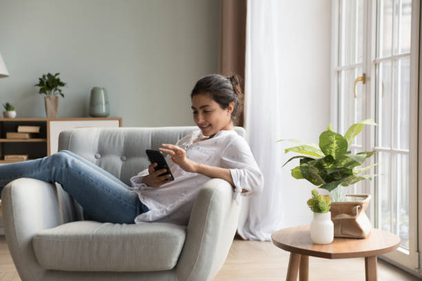 istock Cheerful relaxed young Indian woman using mobile phone 1412950912