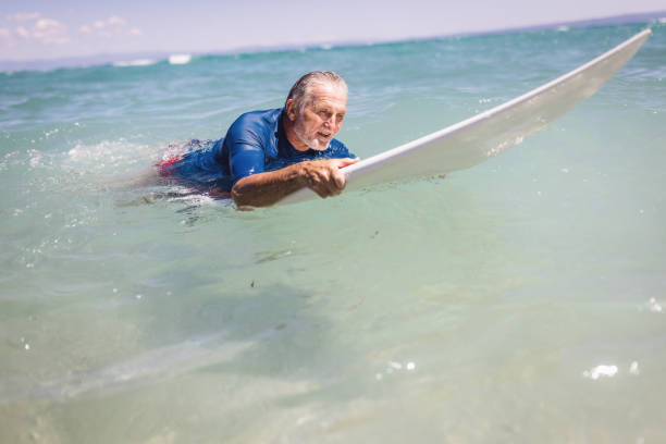 istock Senior man surfing in the sea 1412951519