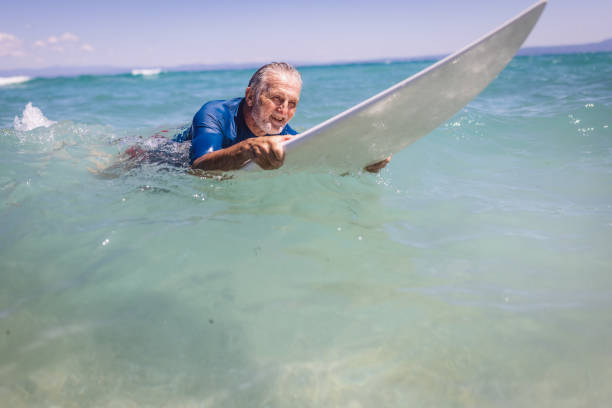 istock Senior man surfing in the sea 1412951592