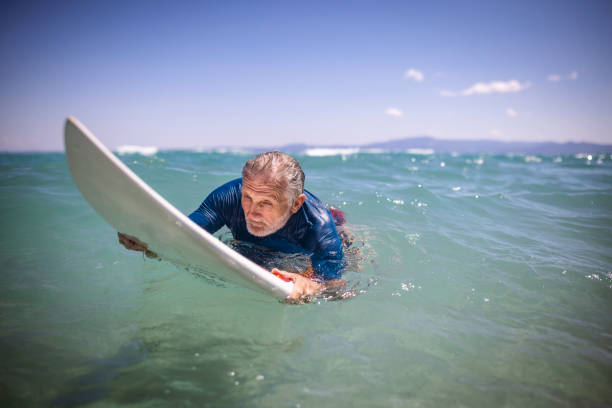 istock Senior man surfing in the sea 1412951699