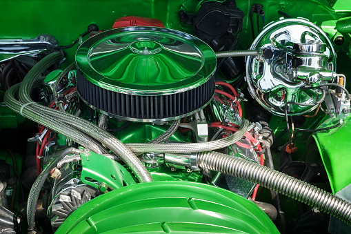 Muscle car engine in close up. Automobile accessories concept. Internal green color, shiny, and nice design of engine.