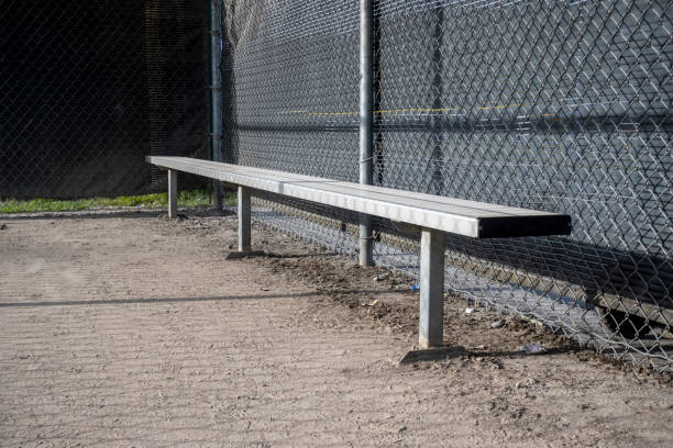 スポーツ場の野球ダグアウト内の金属製ベンチの斜めの眺め - dugout baseball bench bat ストックフォトと画像