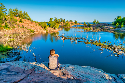 Child enjoys Lake Huron coastline landscape in Killarney Provincial Park Ontario, Canada.