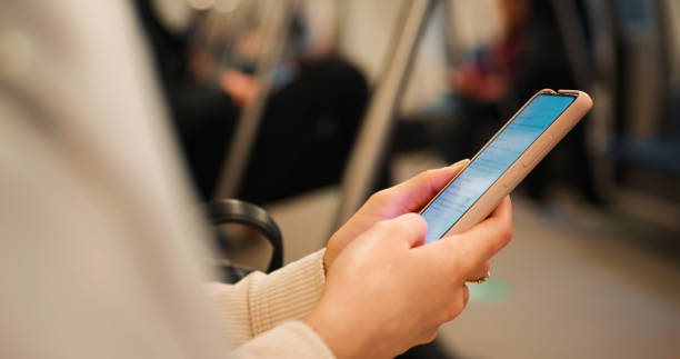 istock Woman scrolling on internet sitting on a crowded train. 1412954026