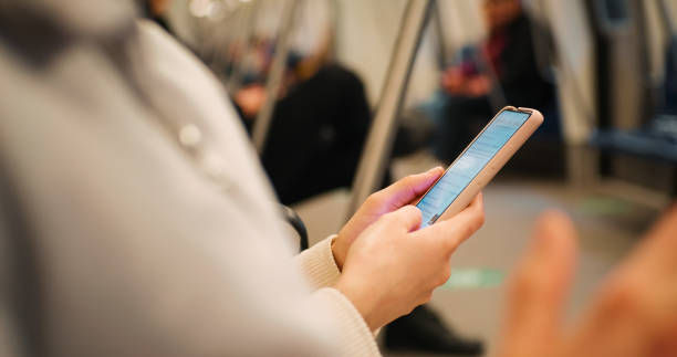 istock Woman hands close up using smartphone on the subway. 1412954032
