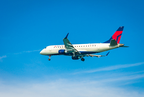 Boston, Massachusetts, USA- May 20, 2022- A Delta Connections aircraft has lowered its landing gear in preparation of  landing at Logan International Airport in Boston.